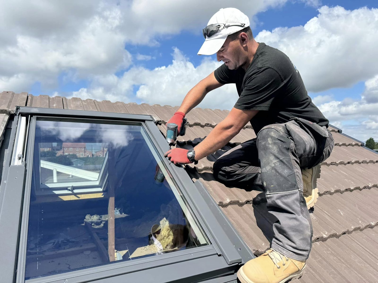 A Roof Pro roofer fitting a roof window into a tiled roof